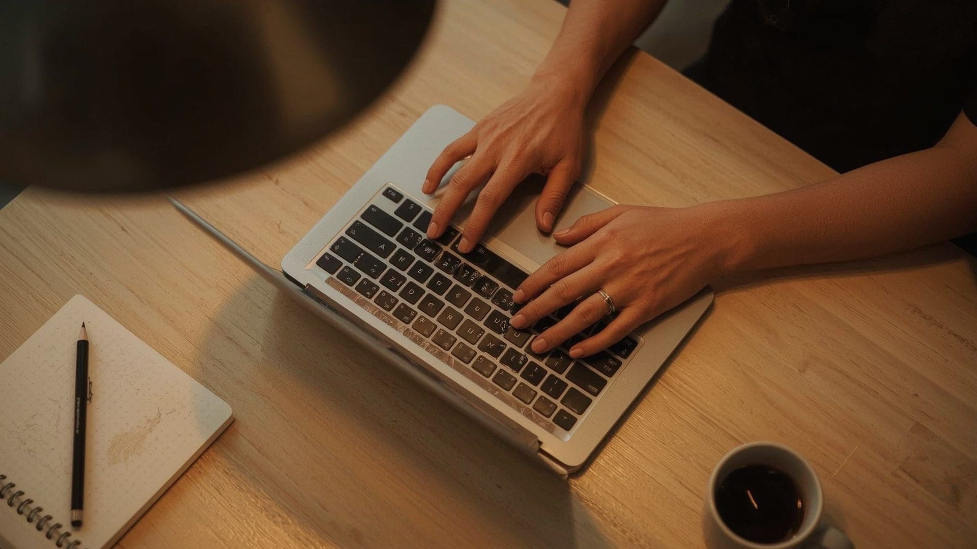 Business owner comparing checking account features using laptop and debit card at coworking desk
